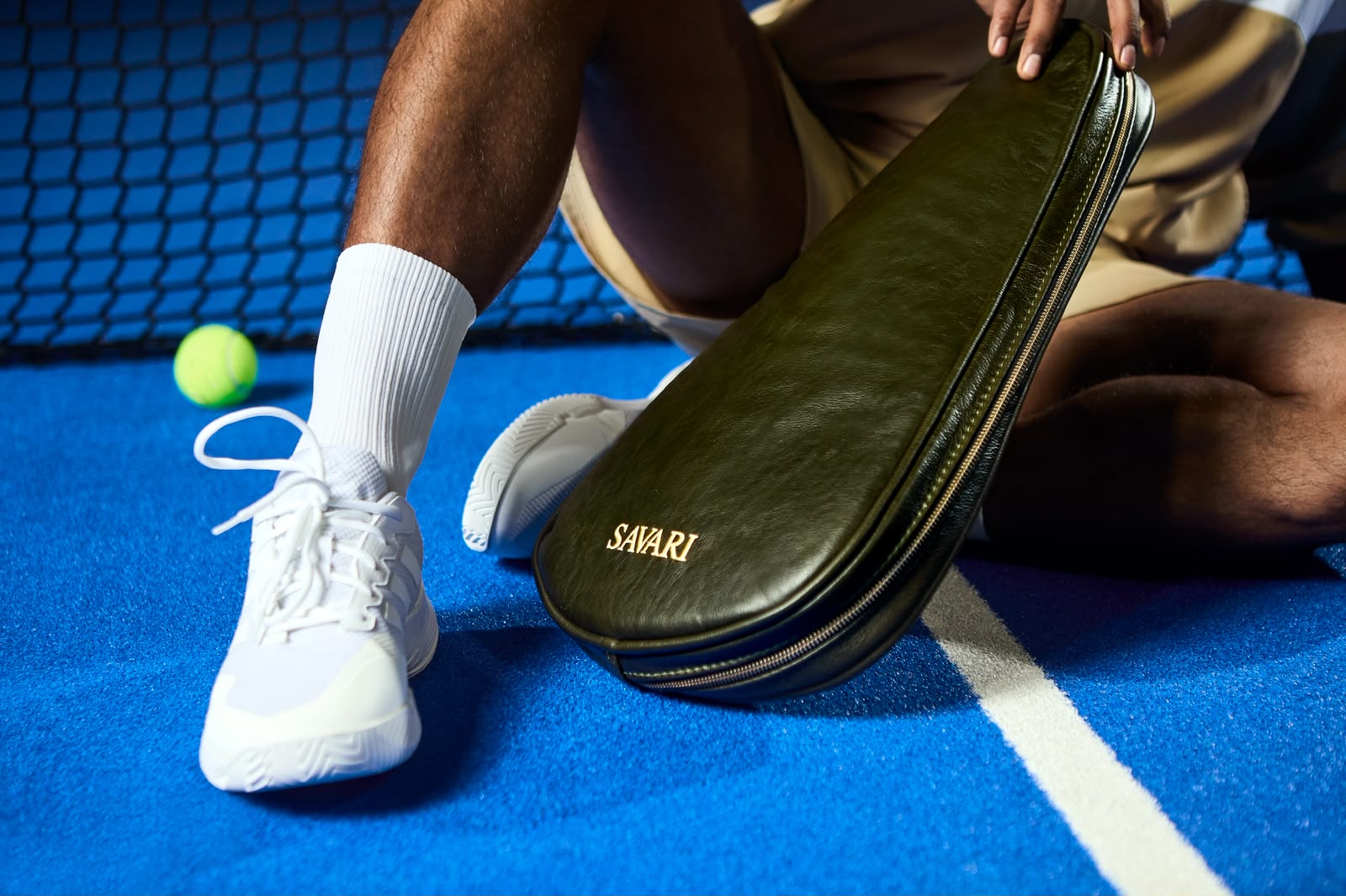 Olive leather Savari padel bag on a blue court